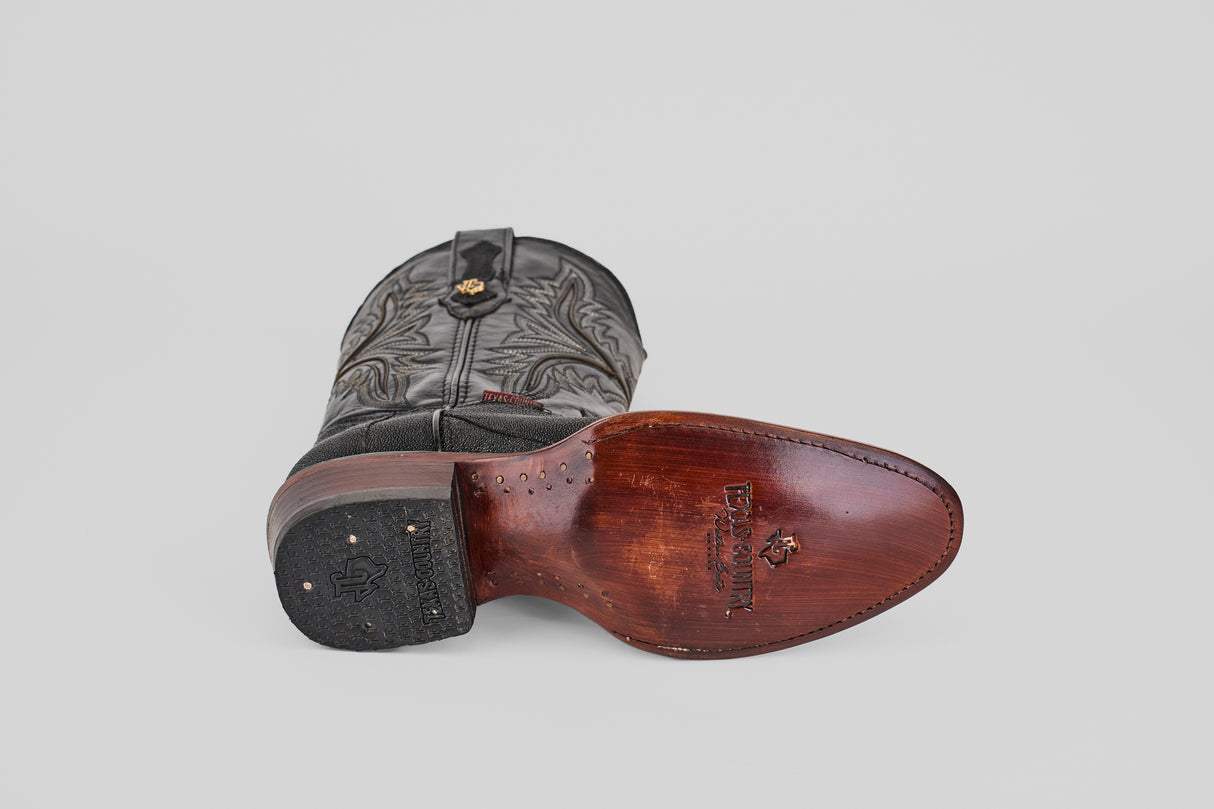 The Ranger – Black – Round Toe boot is shown on its side, featuring a black leather upper, detailed brown sole with visible stitching and brand markings, decorative stitching, and a small gold emblem near the top.