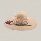 The 30X Hexagon - Open Crown is a beige wide-brimmed straw hat with a patterned perforated crown, grey band featuring a round emblem, and maroon tag on the brim, shown against a neutral background.