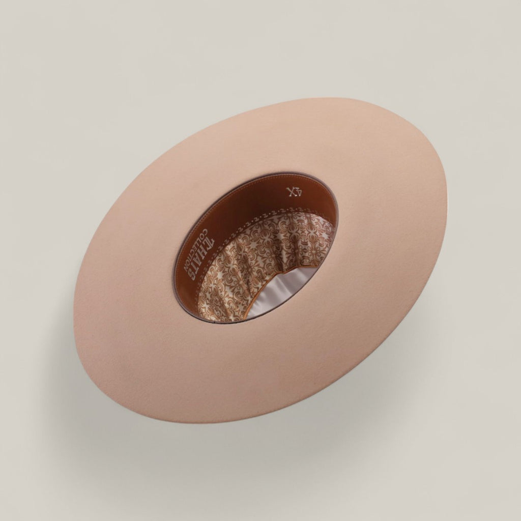 The 4X - Belly - TC Hats is displayed upside down, featuring a beige Western style with a shapeable crown, brown leather inner band, and patterned fabric lining, all set against a plain light background.
