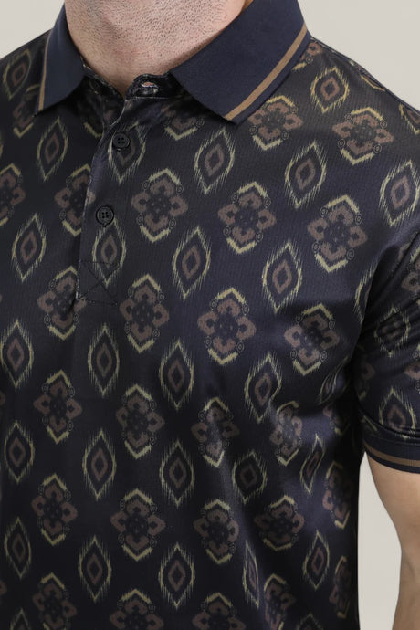 A close-up of a person wearing the Mens Modern Fit Stretch Cotton Black Polo with Aztec Print (AZP10859), featuring a geometric pattern in brown and gold, a black collar, and button-down front.