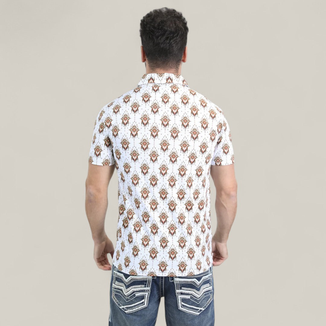 A man with his back to the camera wears the Mens Performance Fabric Modern Fit Stretch Aztec Print White Polo - PGP10870 and blue jeans with white-stitched back pockets. The polos bold geometric design contrasts with the plain beige background.
