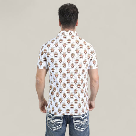 A man with his back to the camera wears the Mens Performance Fabric Modern Fit Stretch Aztec Print White Polo - PGP10870 and blue jeans with white-stitched back pockets. The polos bold geometric design contrasts with the plain beige background.