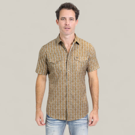 A man stands facing forward, wearing the Mens Performance Western Short Sleeve Aztec Print Camel Shirt (PGW10645) with faded blue jeans, set against a plain light beige background.
