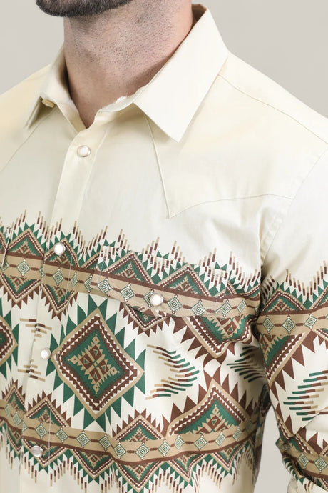 A man wears the Mens Western Modern Fit Cotton/Spandex Long Sleeve Beige Shirt with Snaps (WPL10677), featuring a pointed collar, geometric brown, green, and turquoise tribal pattern, pearl snap buttons, and long sleeves.