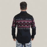 A man faces away from the camera, wearing the Mens Western Modern Fit Cotton/Spandex Long Sleeve Black Shirt with Snaps (WPL10750) featuring a red, white, and purple geometric pattern on the back and sleeves, paired with light jeans. The background is beige.