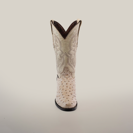 The Karoo Ostrich Print Bone - Round Toe cowboy boot showcases intricate stitching on a plain white background. Handcrafted with a pointed toe, slightly curved top, and leather sole, its ostrich print texture adds distinctive elegance.