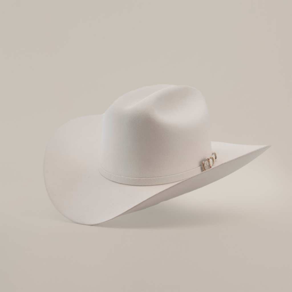 The 100X Independecia White is a luxurious cowboy hat made from full beaver fur. Featuring a broad brim, a slightly creased crown, and small decorative detail on the side, it rests elegantly against a plain light background—a true emblem of premium western headwear.