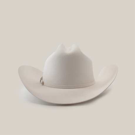The 500X Superior White is a luxurious belly beaver fur cowboy hat with a slightly curved brim and distinct crown crease. Set on a plain white background, it boasts an elegant decorative band around the base of the crown.