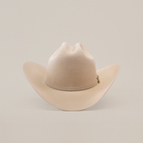 The 10X Jerarca Belly is a beige fur felt cowboy hat with a wide brim and creased crown, embodying classic western style, set against a plain white background.