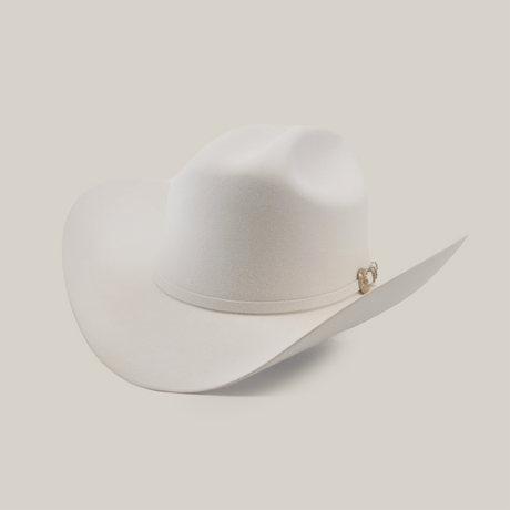 The 500X Superior White is a luxury Western cowboy hat with a wide brim and curved crown, made from top-quality belly beaver fur. It features a subtle band with a small gold emblem on a plain, light background.