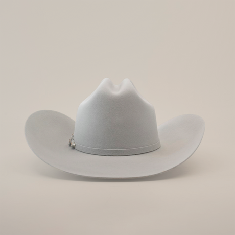 The 10X Jerarca Platinum, a light gray fur felt cowboy hat from the Larry Mahan collection, features a wide brim and a pin on the band, photographed against a plain white background.
