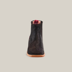 Front view of the Cowhide Hair Black Square Toe ankle boot, crafted from black cowhide leather with a brown sole, against a white background. It features a square toe and pull tab with red detailing.